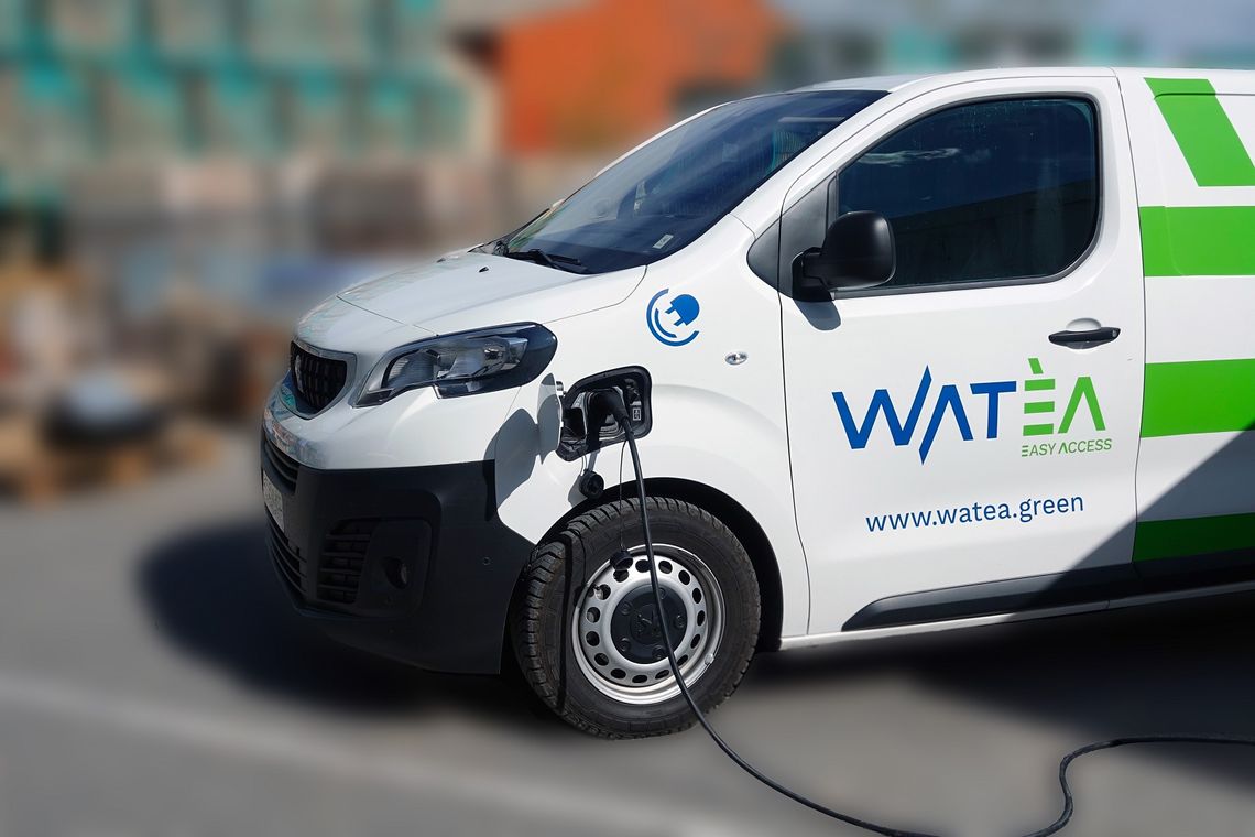 Photographie d'un véhicule électrique Watèa by Michelin relié à une borne de recharge.