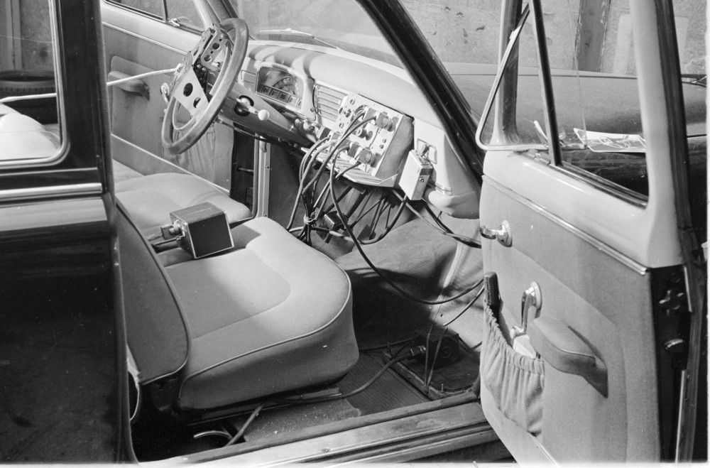 Photographie montrant l'intérieur de l'habitacle d'une voiture. Le tableau de bord est relié par de nombreux câbles à des outils de mesure.