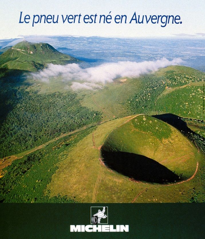 L'image publicitaire montre une photographie de la chaîne des volcans d'Auvergne, en particulier le Puy de Pariou (premier plan) et le Puy-de-Dôme (arrière-plan à gauche). Il est écrit : « Le pneu vert est né en Auvergne ».