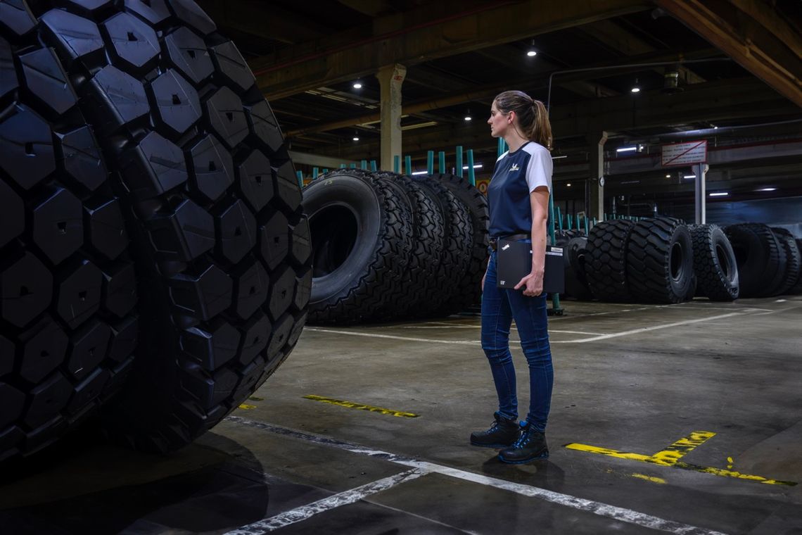 Femme Responsable Ilot Fabrication davant un pneu