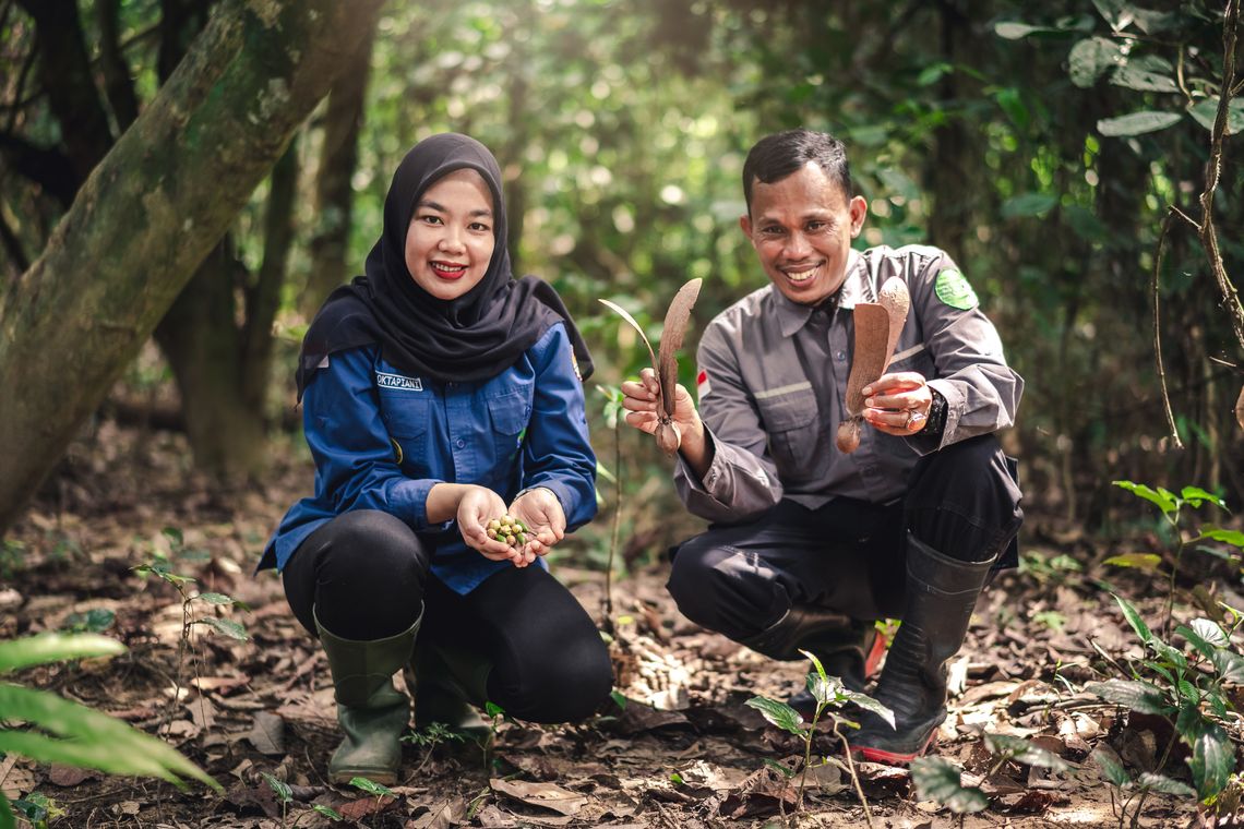 Two Michelin employees collecting natural materials in a forest setting, reflecting purpose, values, and sustainability in Asia Pacific.