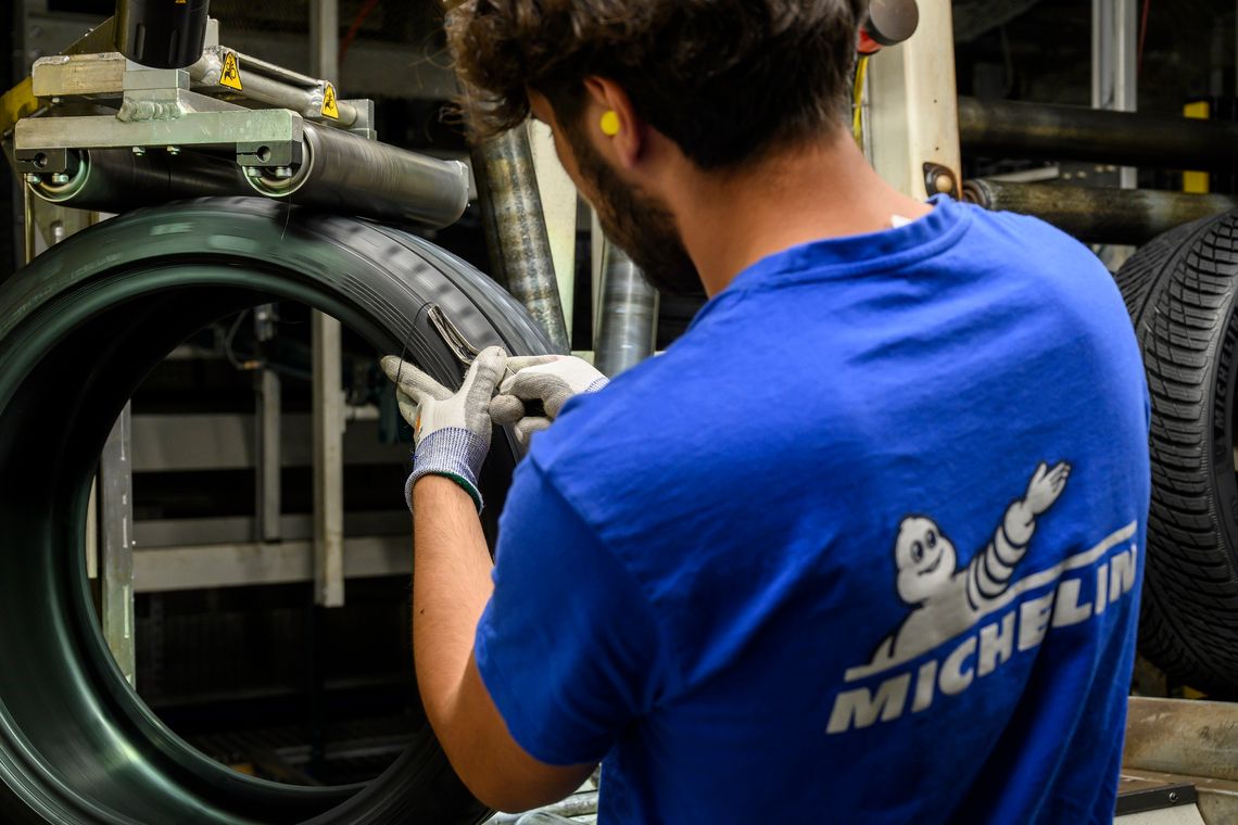 Un agent utilise un outil spécifique à l'étape de confection du pneu