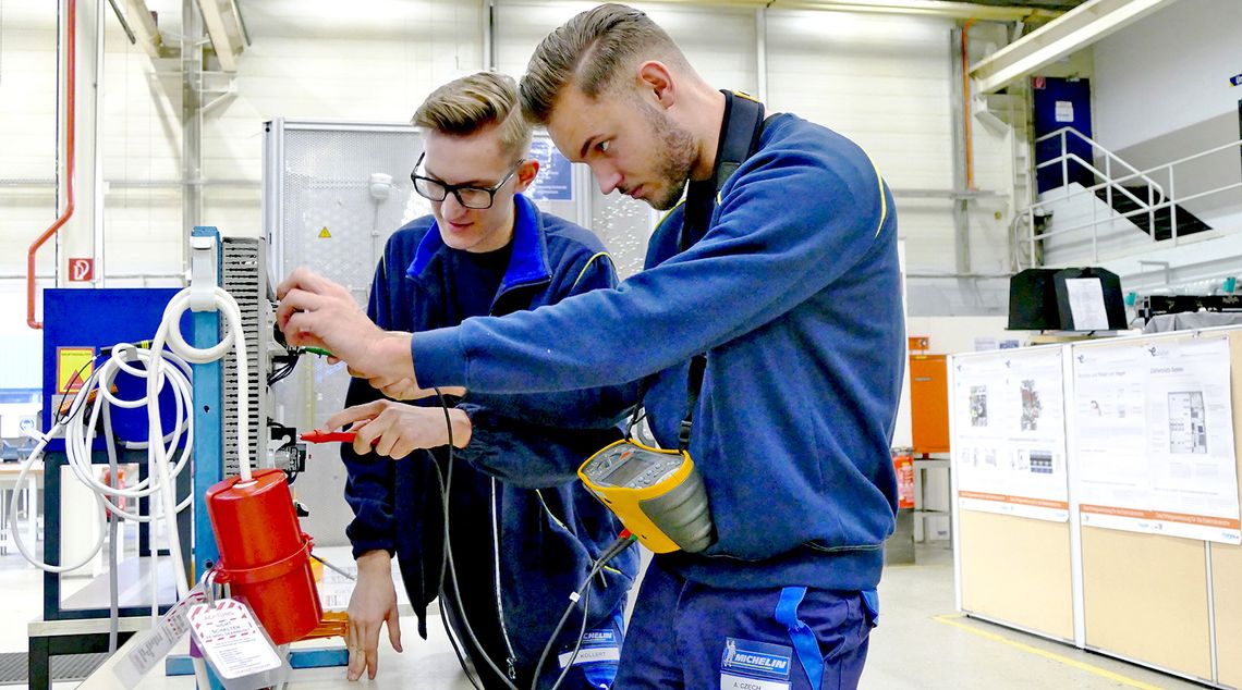 Apprentices work on a machine in a workshop at the Hall32 school.