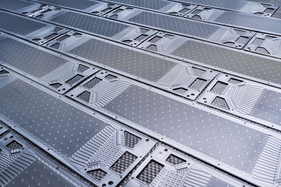 Photograph of fuel cell bipolar metal plates. They are arranged flat against each other.