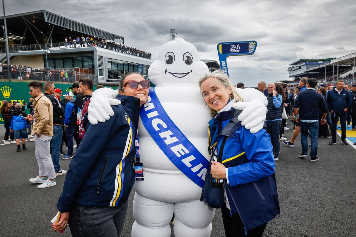 Two Michelin women pose in the arms of the Michelin Man